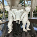 Detalle del rostro y cabello de los querubines en el centro de mesa de porcelana, pieza decorativa clásica para ambientes elegantes.
