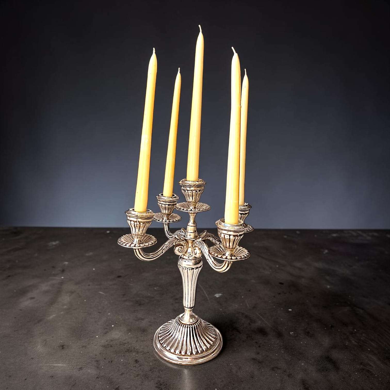 Las velas de tono marfil crean un contraste cálido con el acabado plateado. 