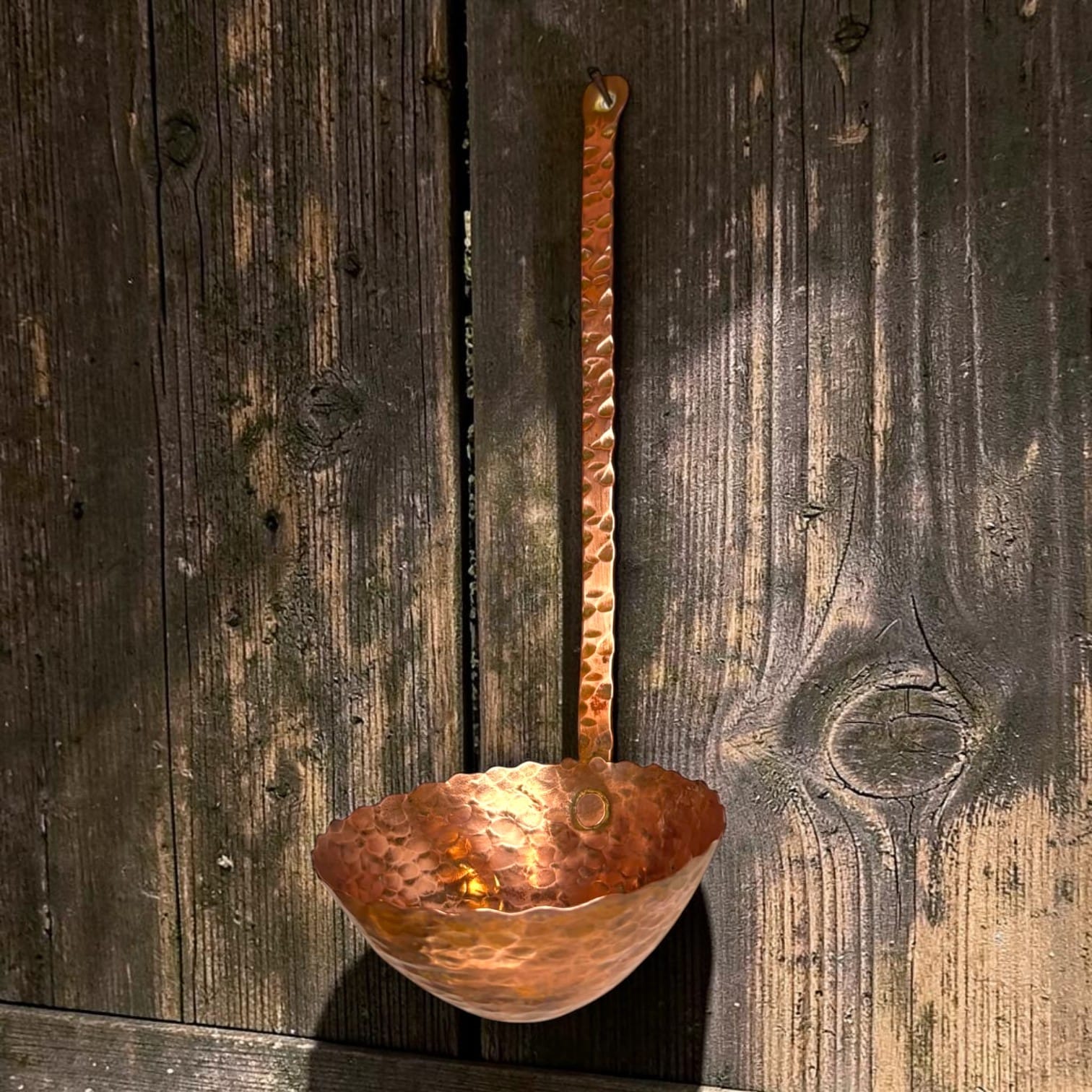 Este cazo antiguo de cobre martilleado conserva la forma tradicional de los pequeños utensilios d
