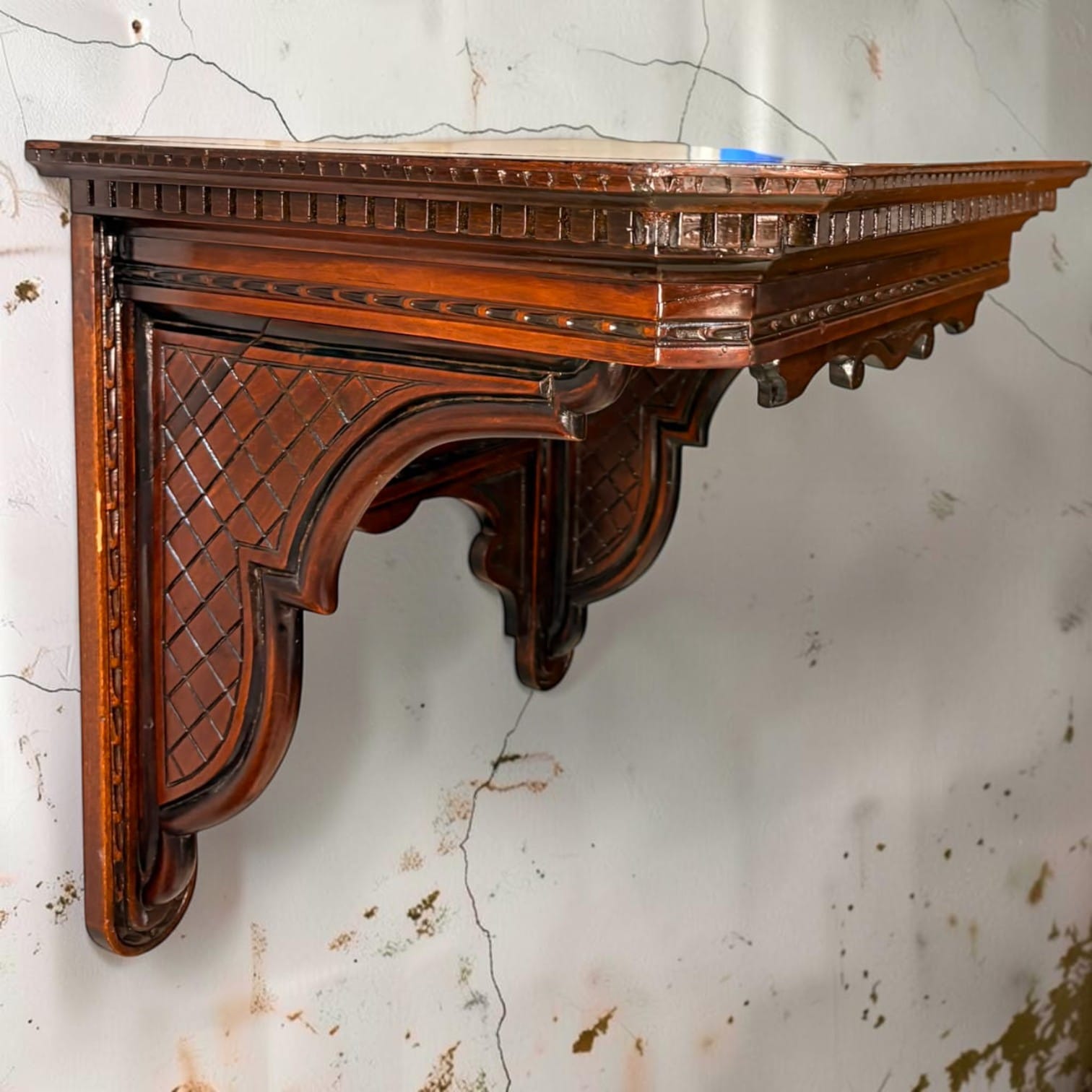 Con 52,5 cm en su dimensión mayor, esta ménsula de pared de madera tallada 