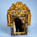 La función original del espejo antiguo de madera dorada es doble: ofrecer una superficie de reflejo y formar parte de la decoración de la estancia.
