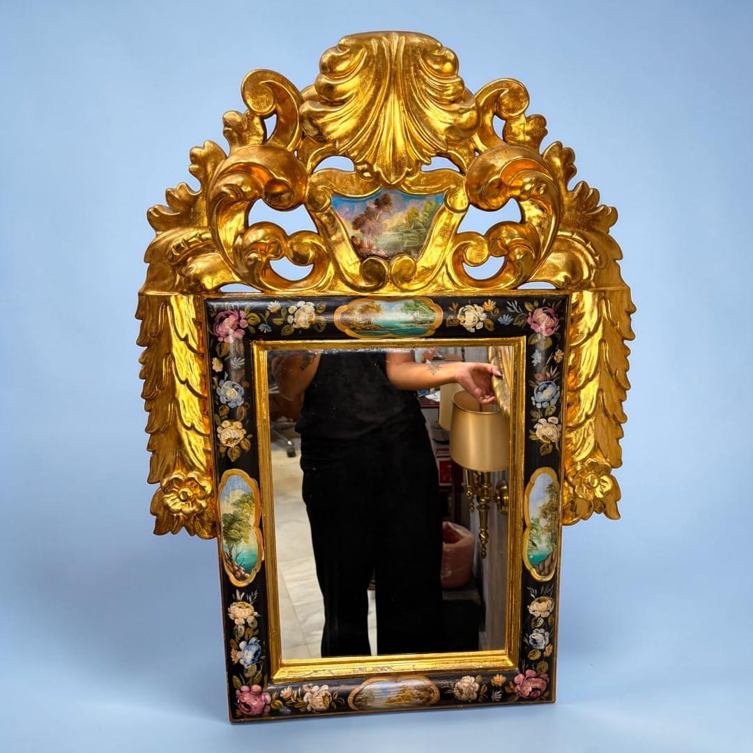 La función original del espejo antiguo de madera dorada es doble: ofrecer una superficie de reflejo y formar parte de la decoración de la estancia.