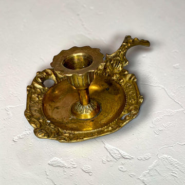 La función tradicional de esta pareja de palmatorias de metal dorado es sostener una vela y facilitar