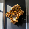  como el espejo antiguo de madera dorada con copete ornamental, que utiliza también el dorado y una fuerte ornamentación en su parte superio