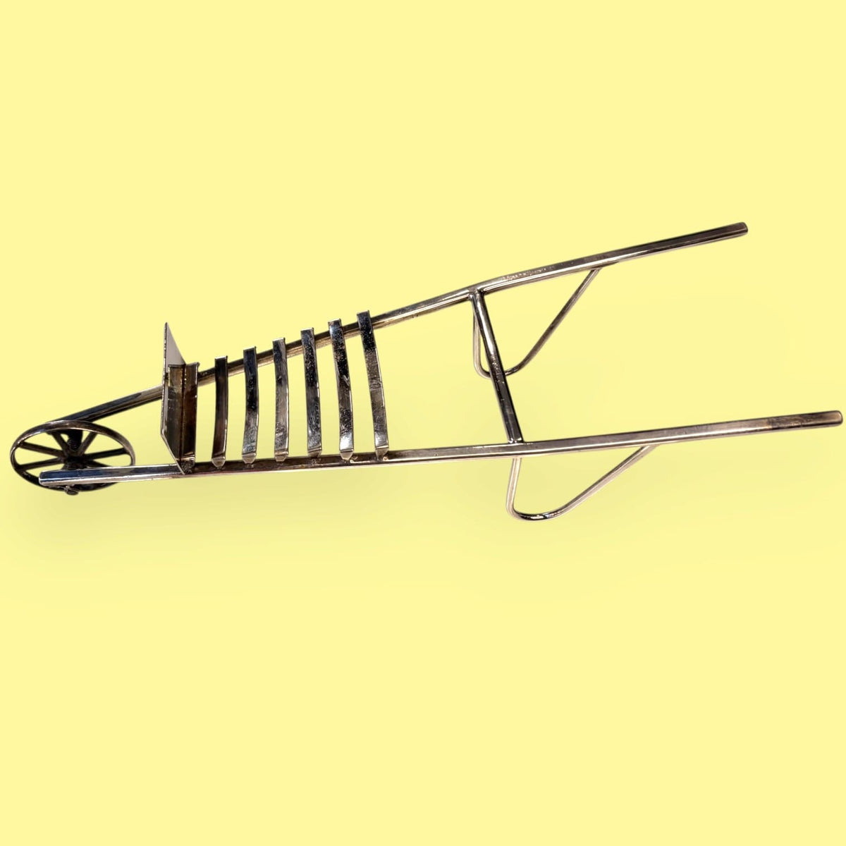  La rueda, los largos brazos y los soportes centrales reproducen una pequeña estructura de transporte, pero adaptada al servicio de mesa.

