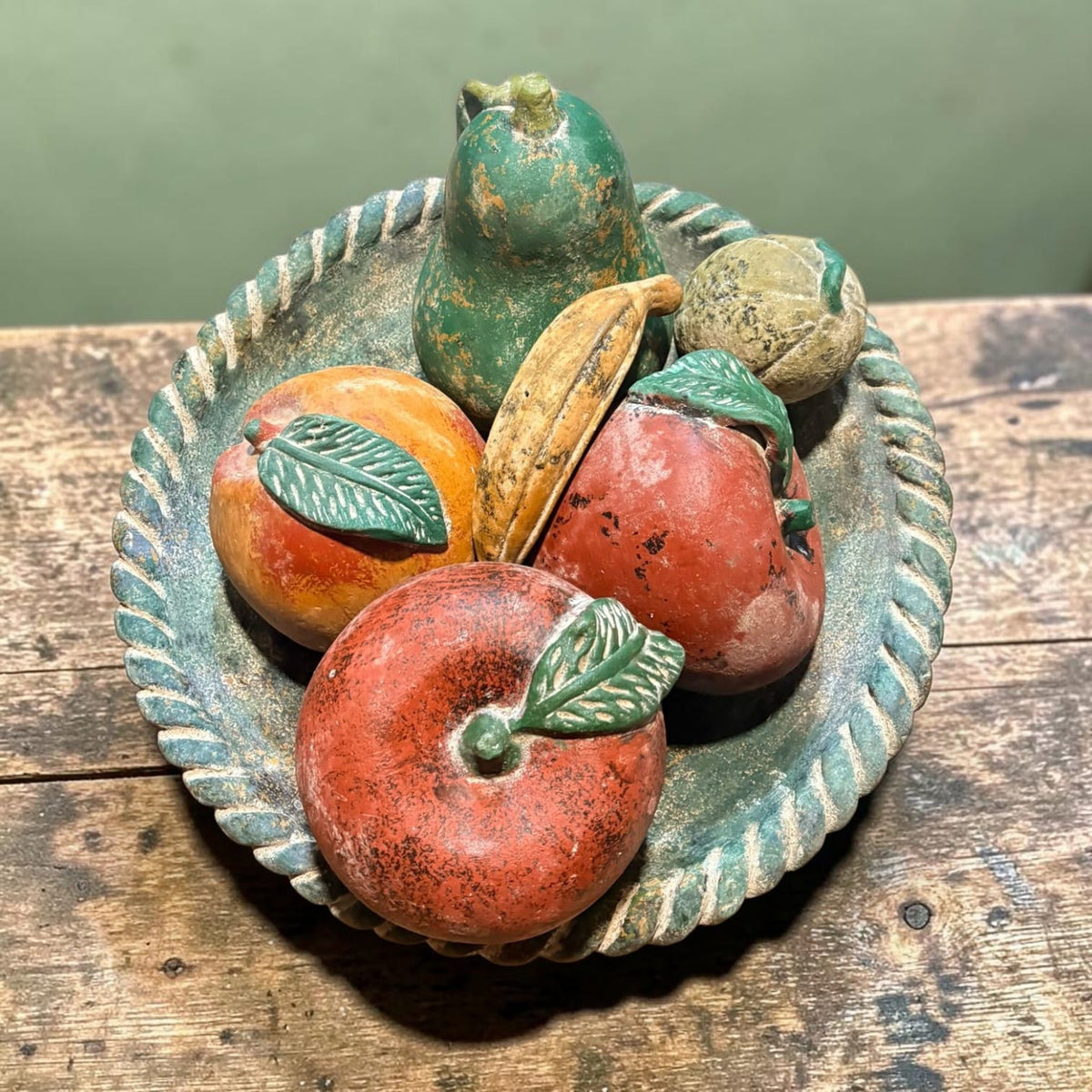 Son detalles especialmente visibles en las frutas y en el fondo verdoso de la bandeja.

