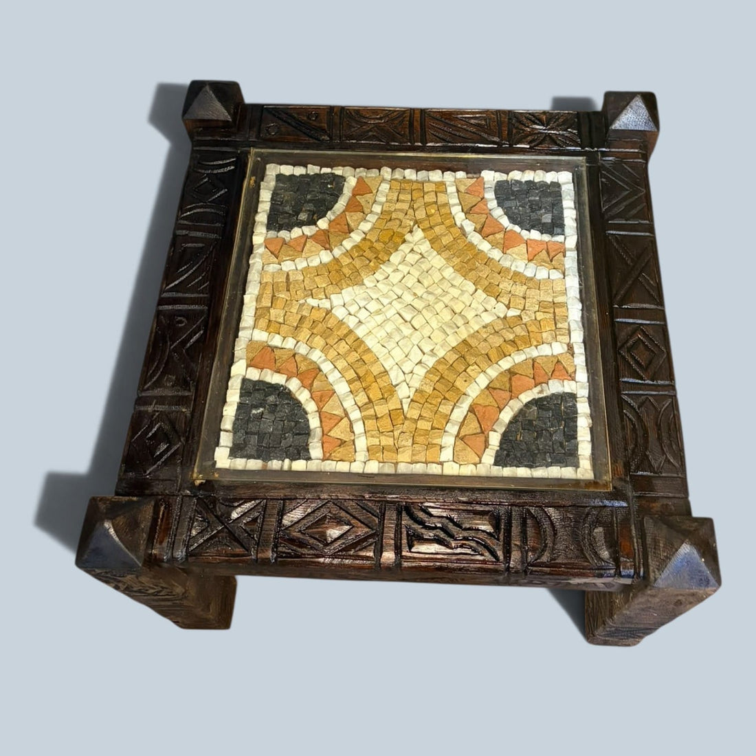Mesa baja de madera tallada con mosaico de piedra y cristal