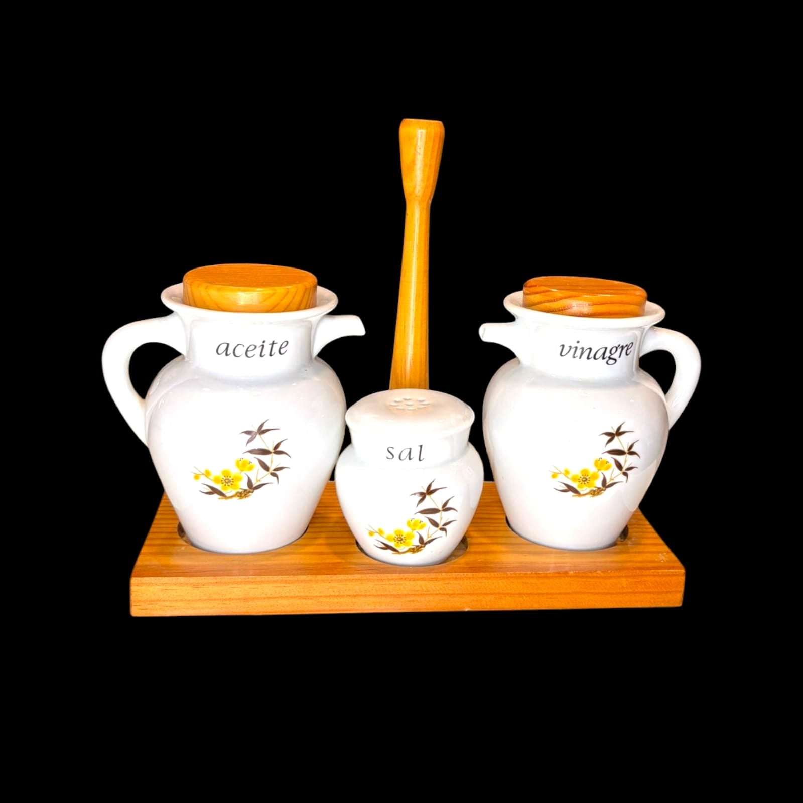 Se observan tarros de porcelana de distintos tamaños, tapas con acabado madera, dos estructuras de madera, una para presentación de mesa y otra en formato expositor, además de piezas auxiliares como plato, cuenco y recipiente de servicio. 