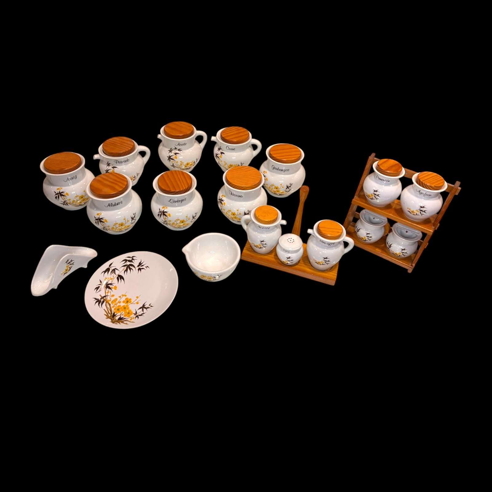 Predomina una porcelana blanca de formas redondeadas, rematada con tapas de efecto madera y decorada con un delicado motivo floral en amarillo y ramas oscuras, un detalle que le aporta frescura, unidad estética y mucho valor visual.
