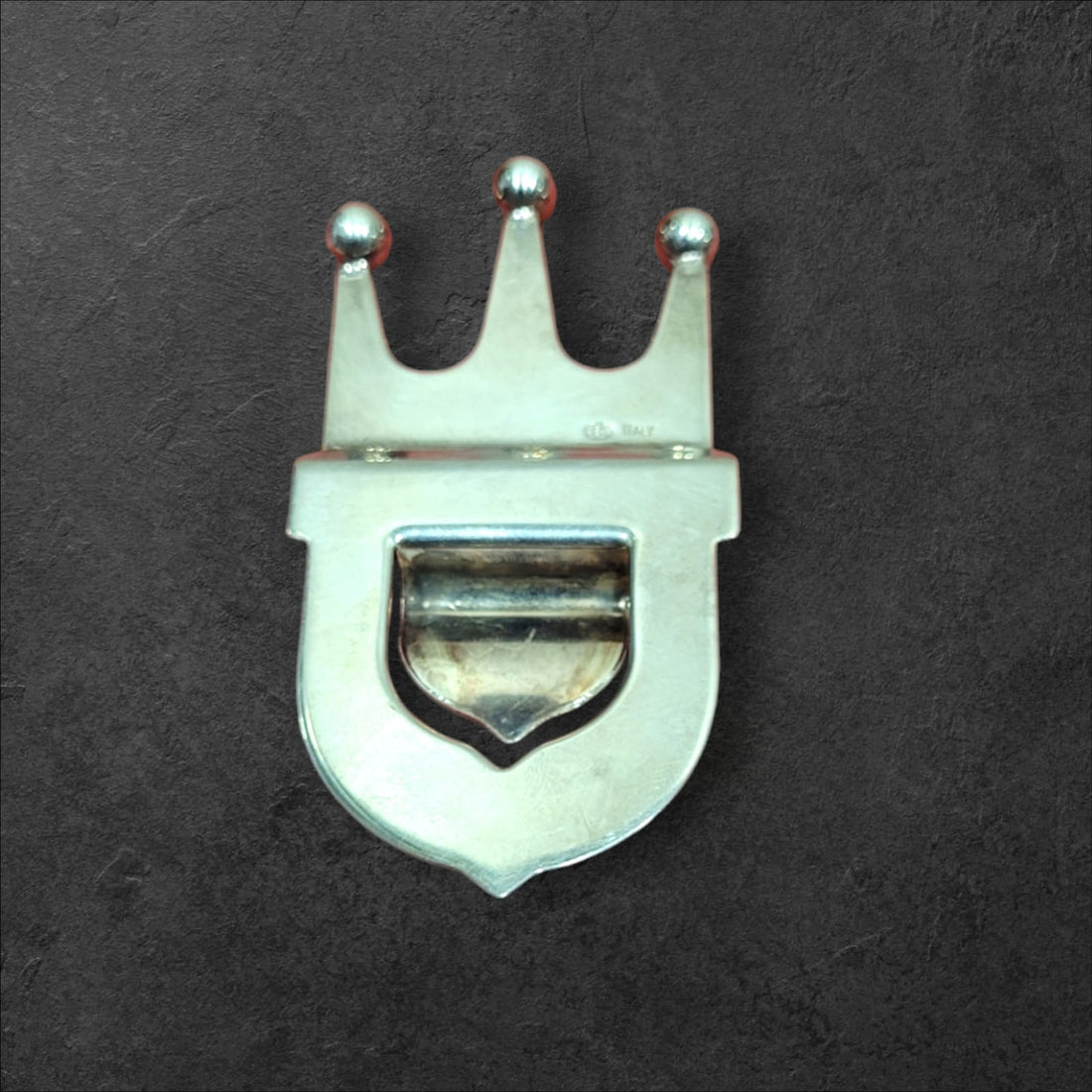 Abrebotellas de metal plateado con diseño de corona, estilo vintage, ideal para decoración y uso en bares o cocinas elegantes.