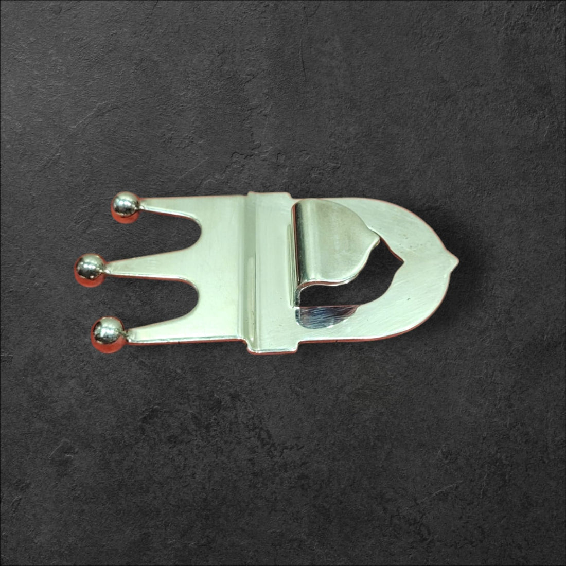 Abrebotellas de metal plateado con diseño de corona, estilo vintage, ideal para decoración y uso en bares o cocinas elegantes.