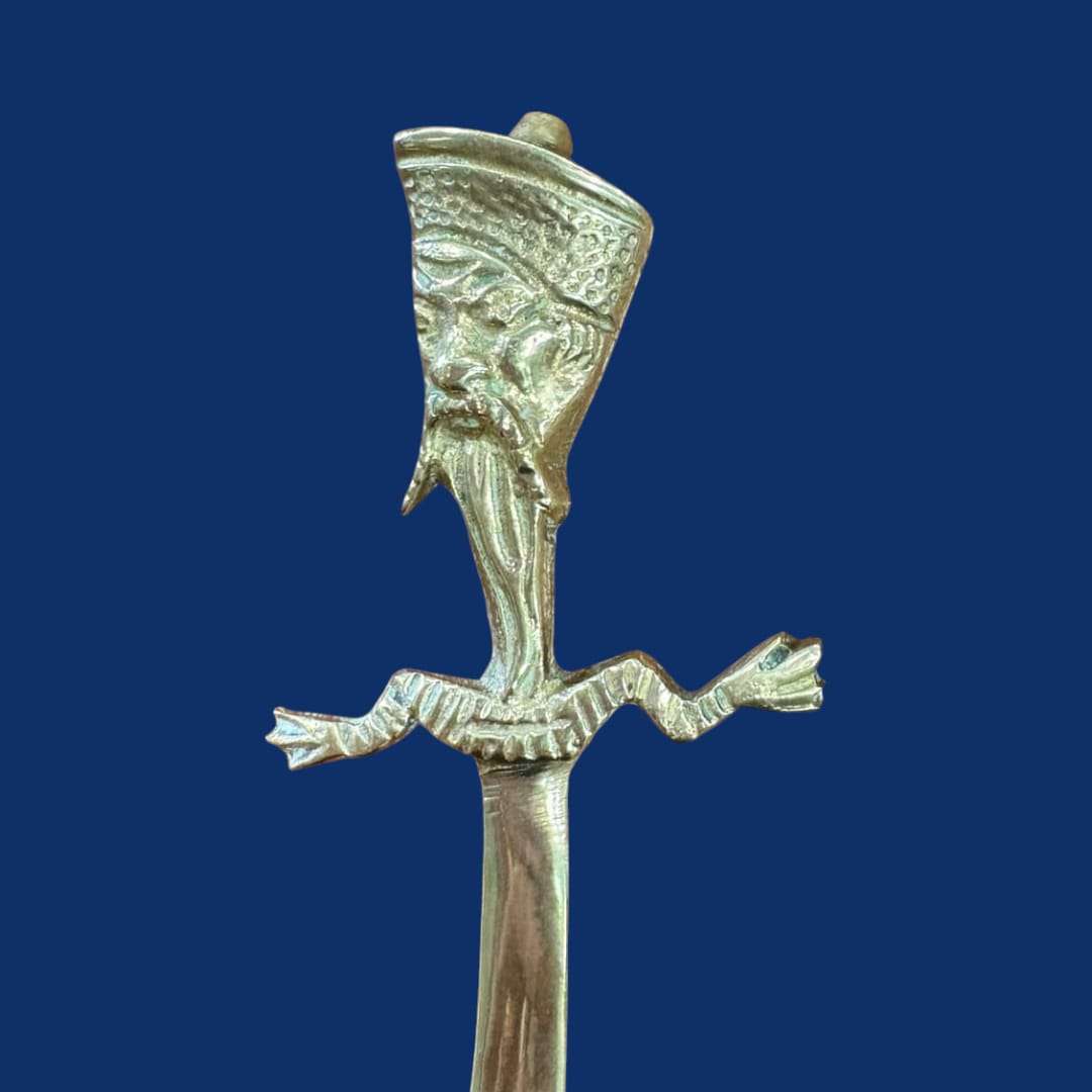 Abrecartas oriental en forma de sable metálico único con empuñadura decorada con figura tallada. Ideal para decoración de escritorio elegante.