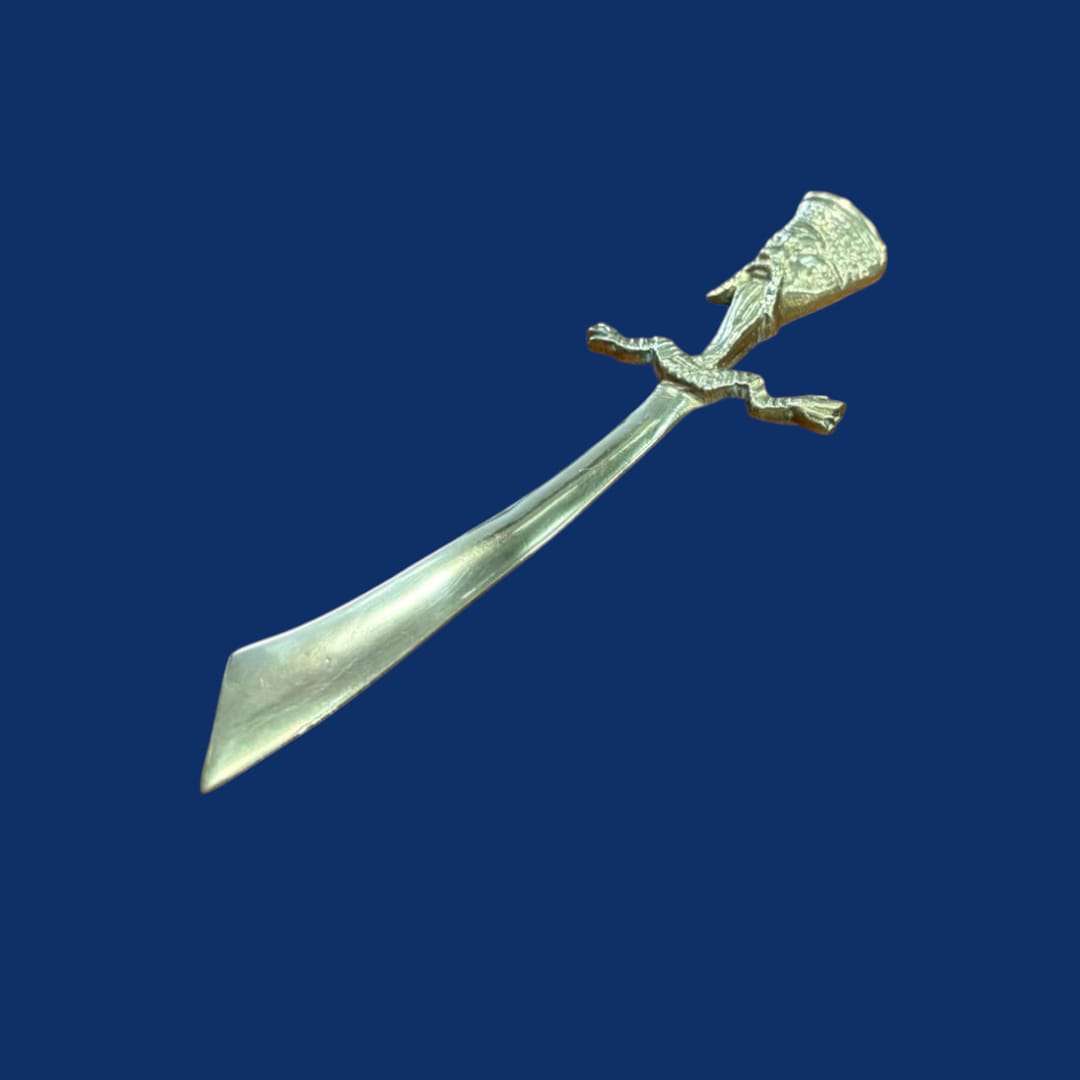 Abrecartas oriental en forma de sable metálico único con empuñadura decorativa, ideal para decoración de escritorio en estilo exótico y artístico.