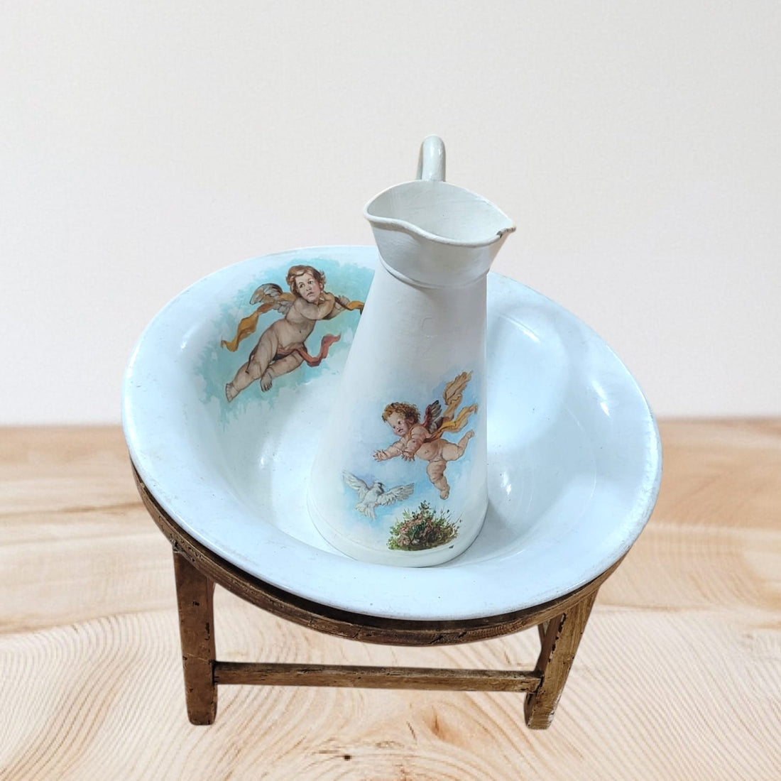 Aguamanil-Palaganero de la Cartuja con jarra decorada con ángeles y pie de madera, ideal para decoración vintage y coleccionistas.