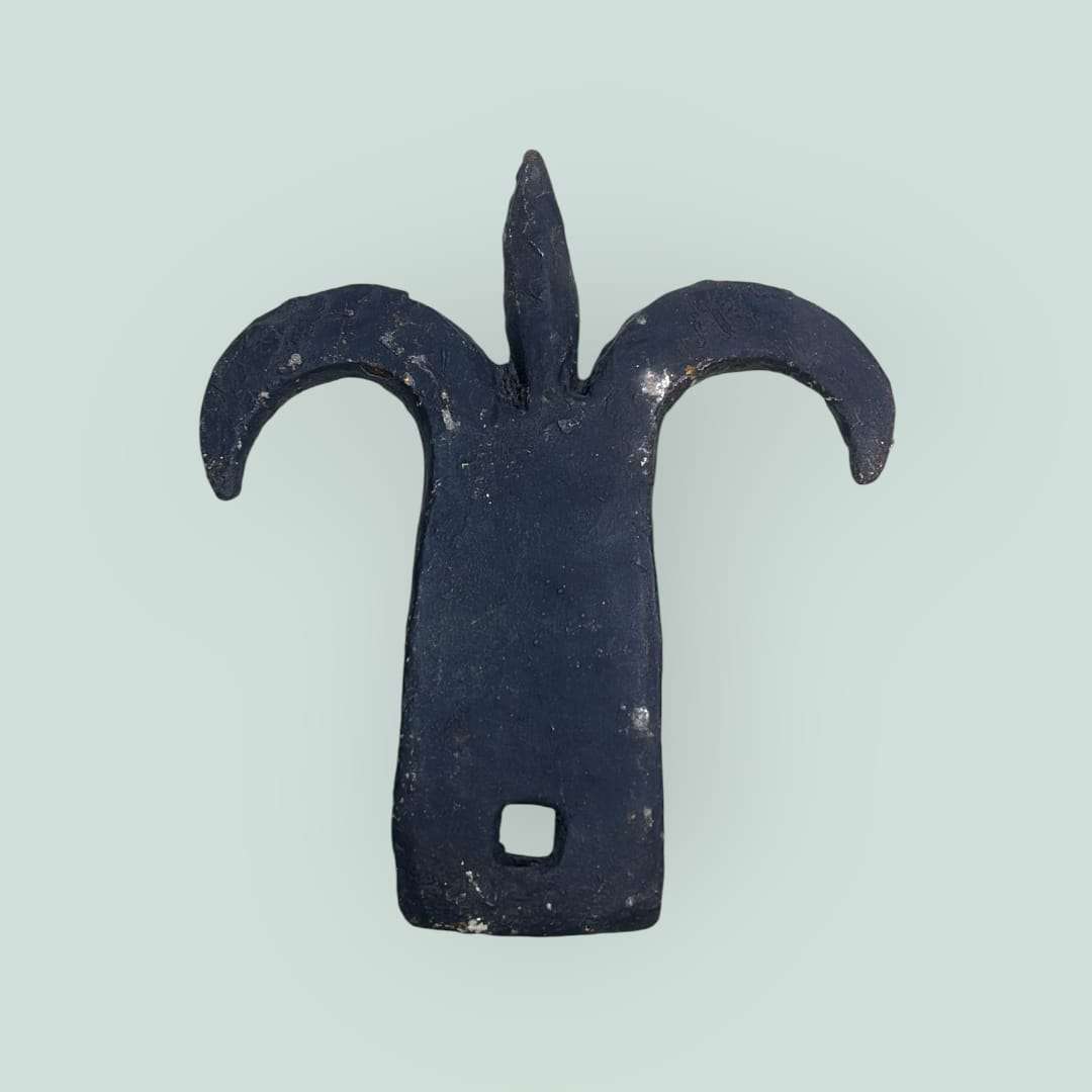 Detalle superior de la aldaba con punta central tipo flor de lis.