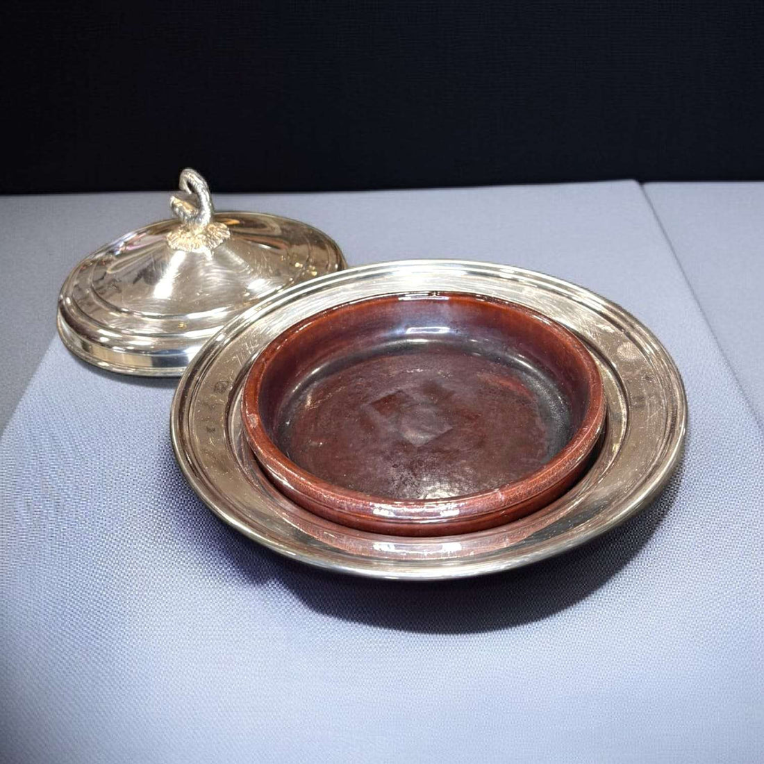 Angulera de metal plateado con tapa decorativa