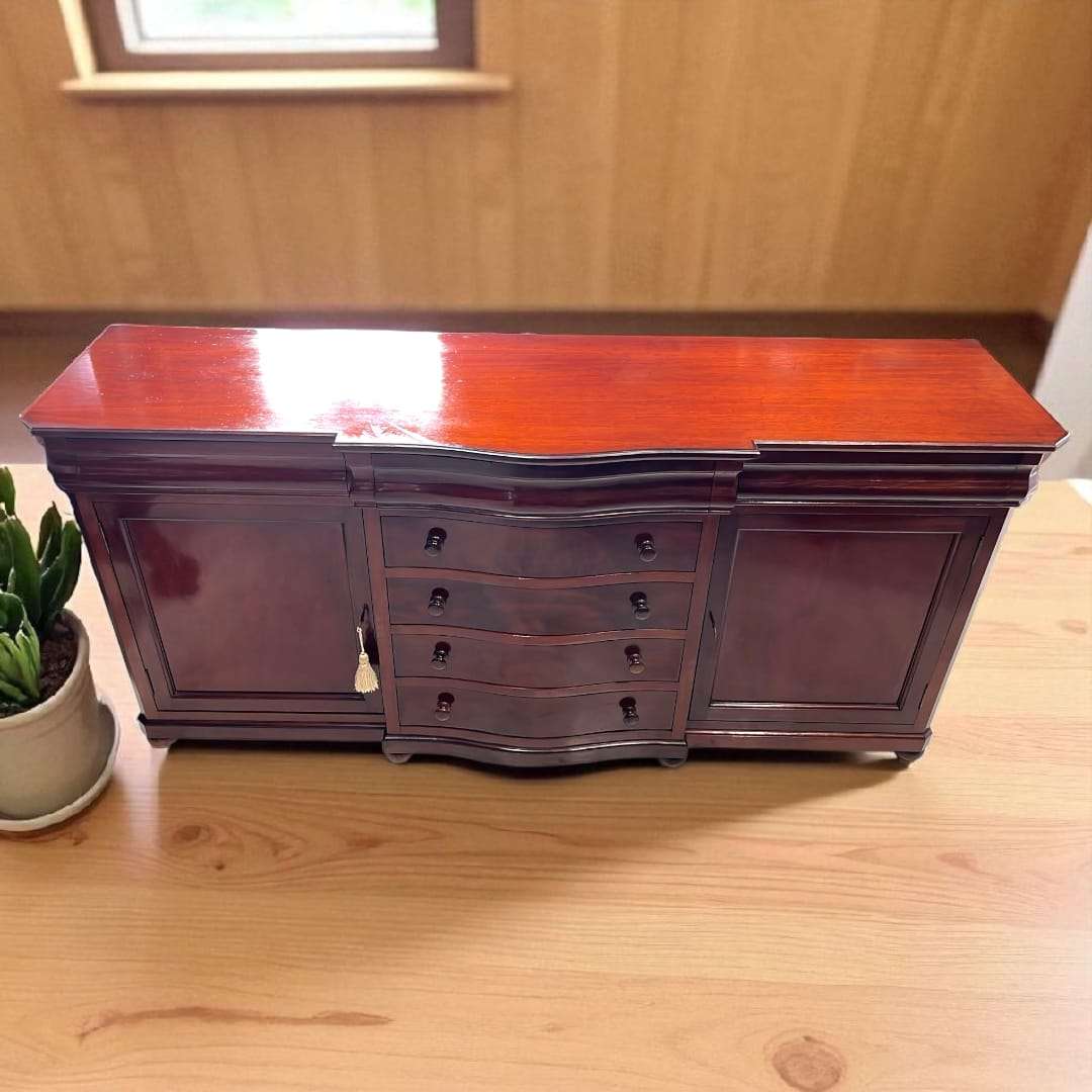 Aparador de caoba antiguo con cajones secretos y llaves, acabado brillante y diseño clásico, ideal para decoración de interiores elegantes.