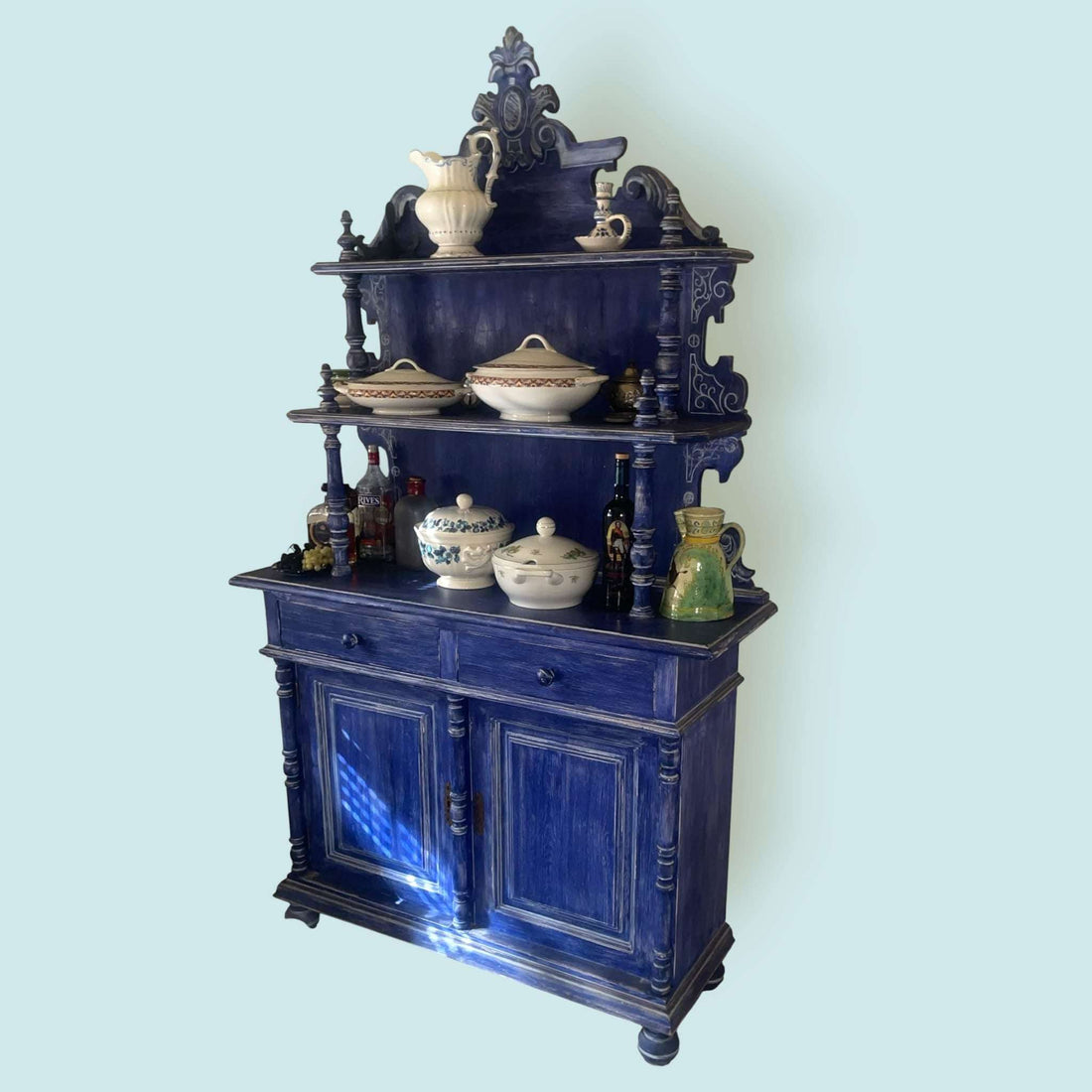 Aparador decorado con vajilla y objetos, perfecto para el hogar.