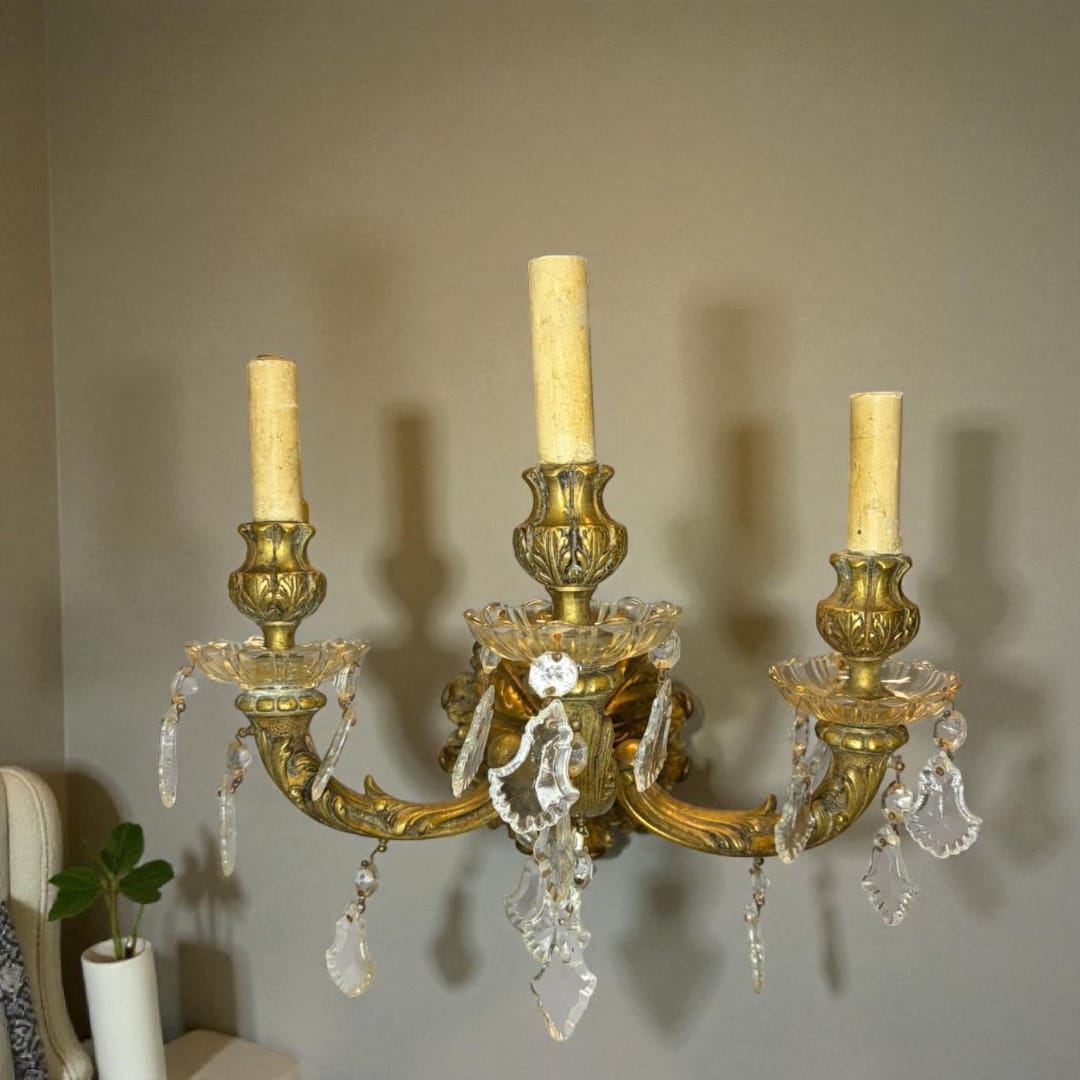 El aplique antiguo de bronce electrificado con lágrimas de cristal es una obra maestra de la iluminación clásica.