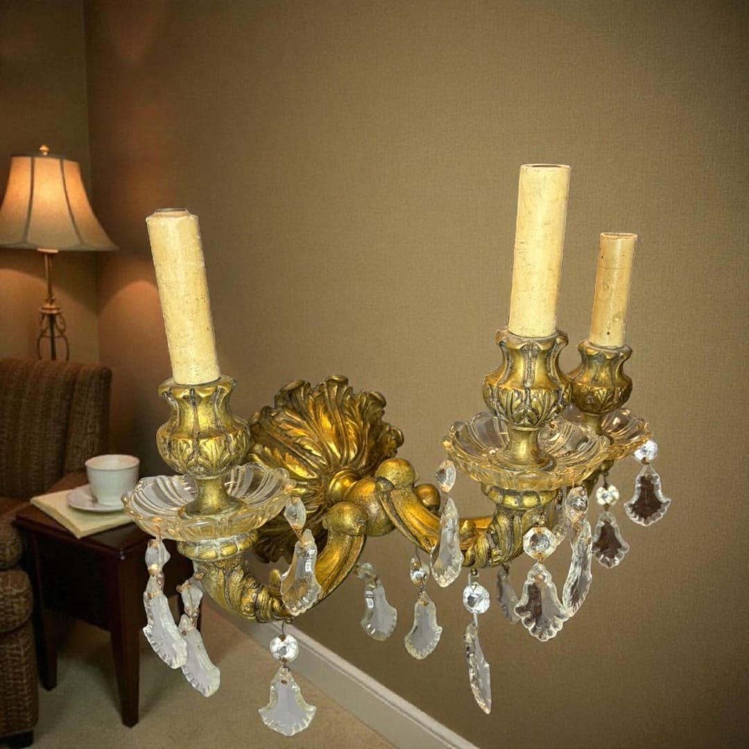 El aplique antiguo de bronce electrificado con lágrimas de cristal es una obra maestra de la iluminación clásica.