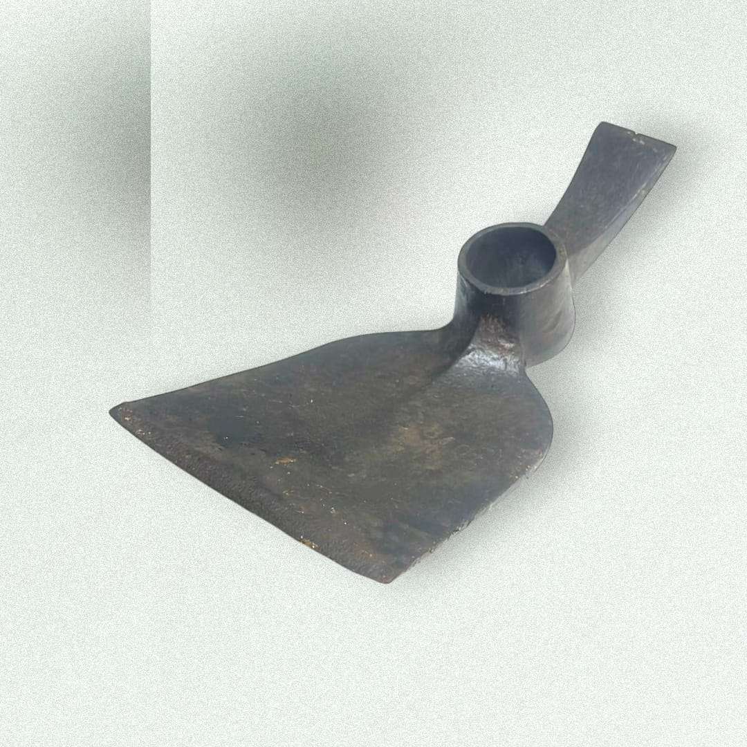 Cabezal de azada doble antiguo en hierro forjado visto en detalle.