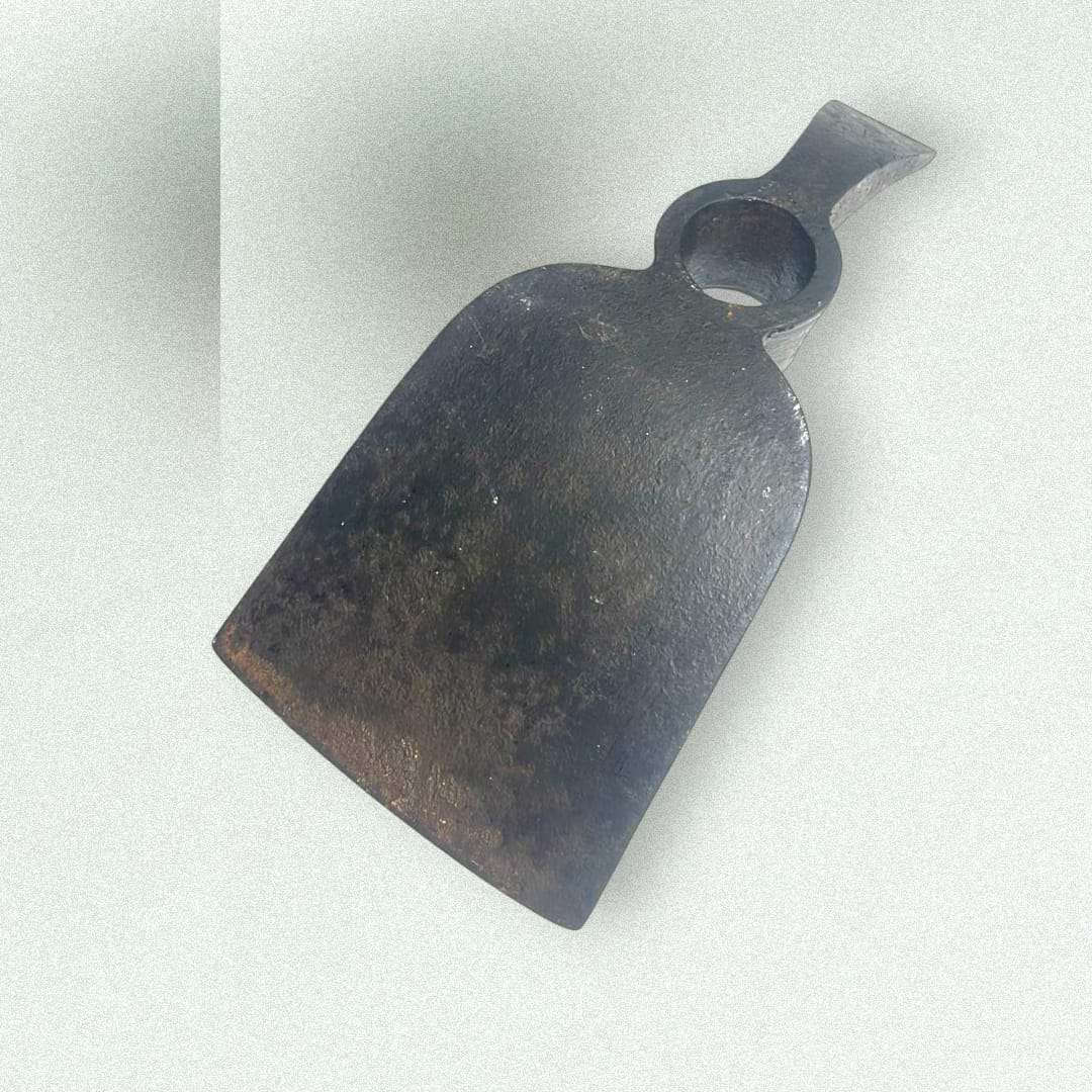 Cabezal de azada doble antiguo en hierro forjado visto en detalle.