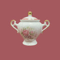 Azucarero TLimognes de porcelana fina con detalles únicos, decorado a mano con flores rosadas y bordes dorados, ideal para decoración elegante.