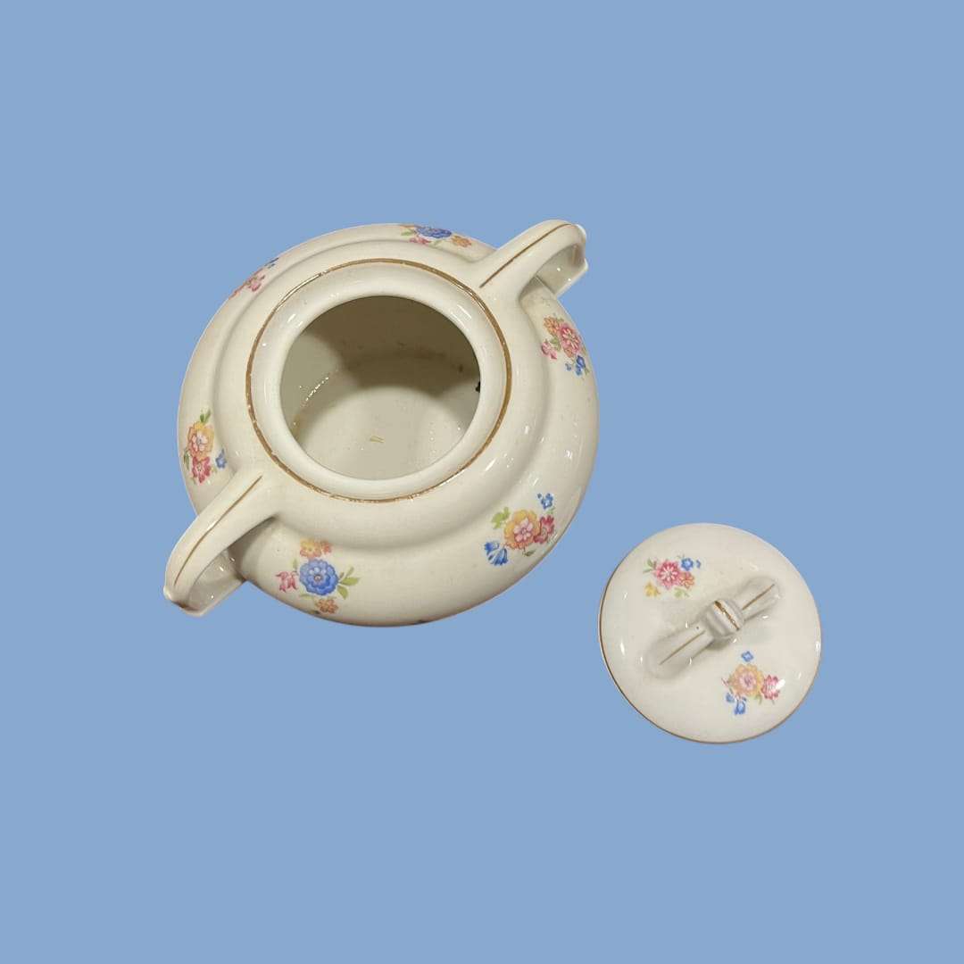 Azucarero Victoria abierto mostrando el interior y la tapa removida, pieza de porcelana decorativa con detalles florales clásicos.