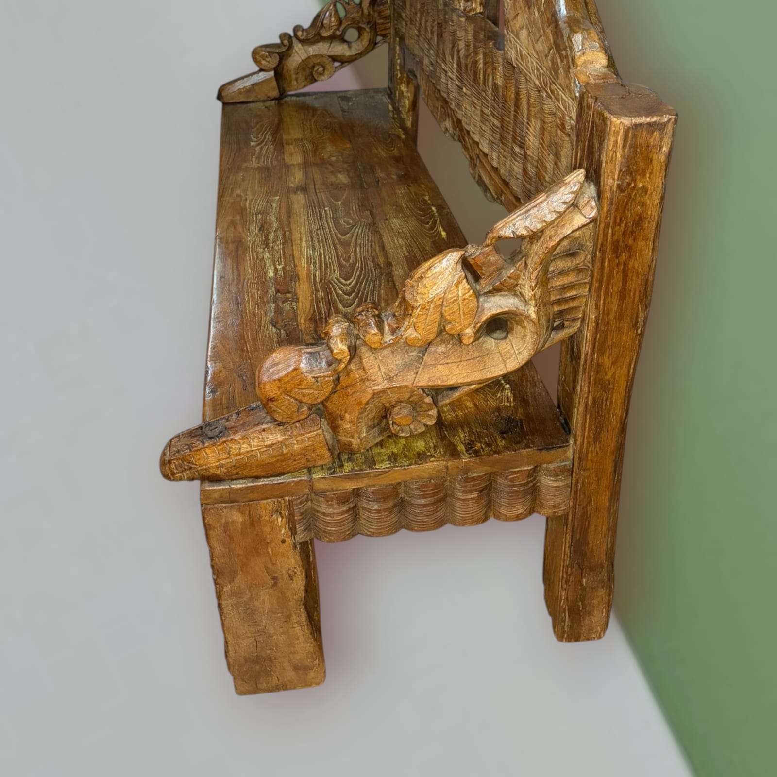 Vista lateral del banco de madera con reposabrazos tallados