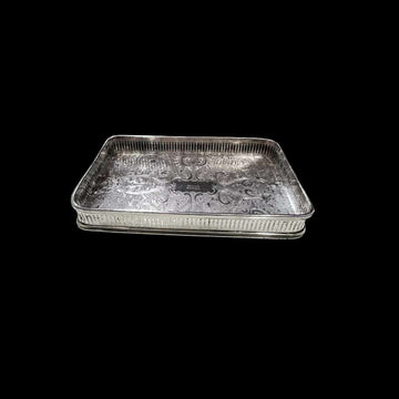 “Vista frontal de la bandeja de metal plateado rectangular grabada.”