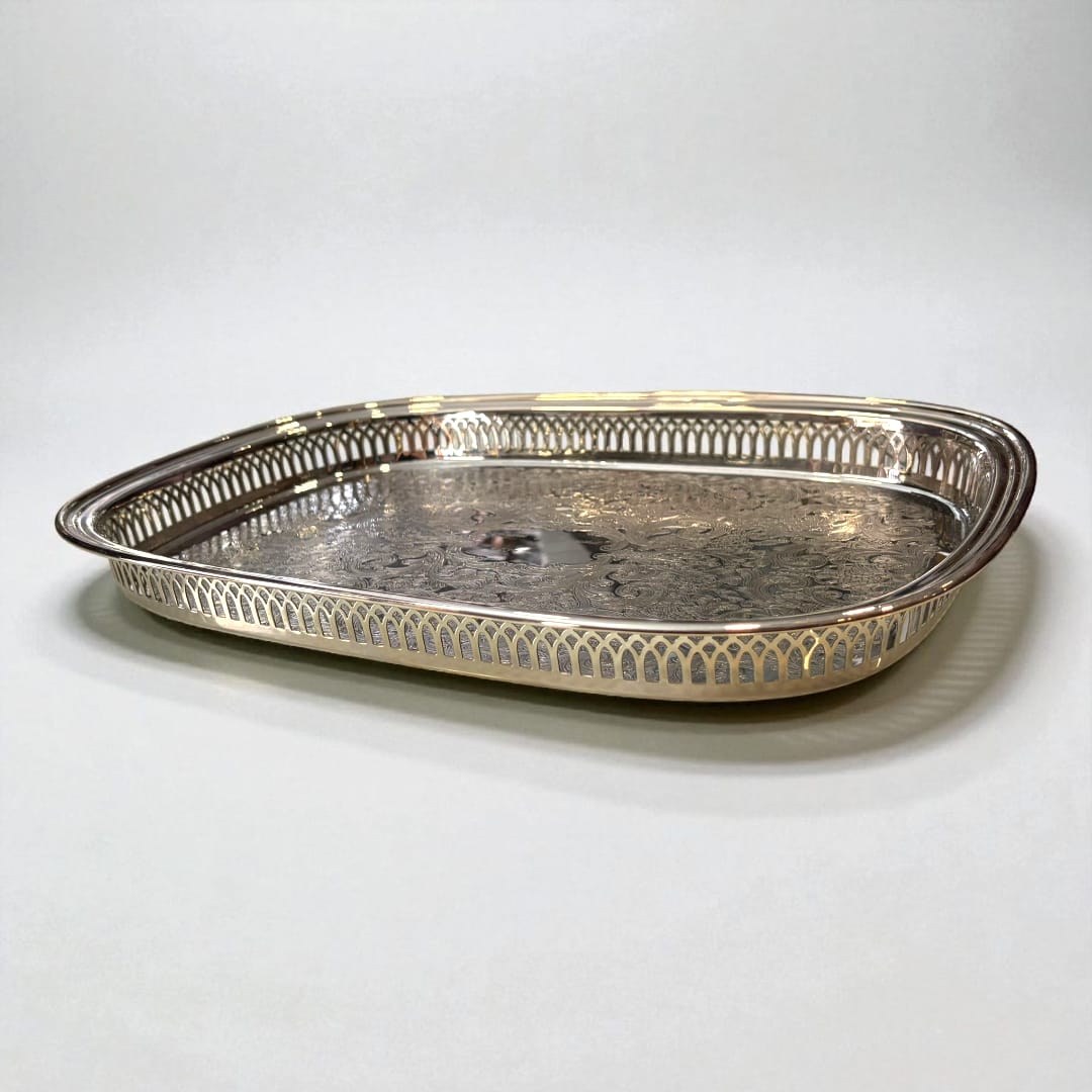 Bandeja de metal plateada grabada con bordes calados.