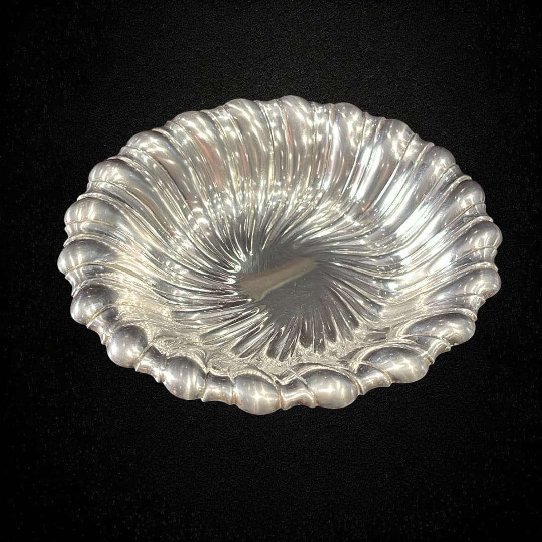 Bandeja de metal plateado vista superior con relieve ondulado.