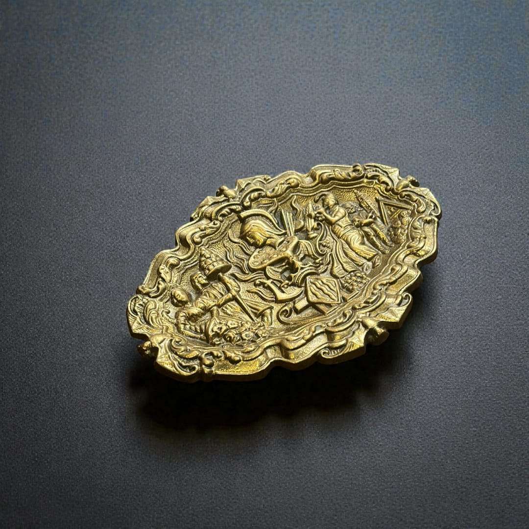 Esta Bandeja de bronce decorativa es una pieza excepcional que destaca por su extraordinario trabajo en relieve y su cuidada composición artística. 
