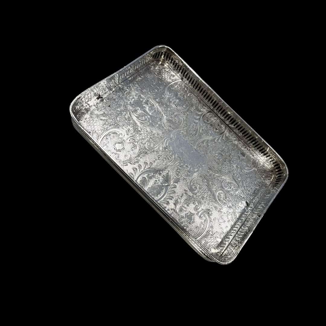 “Vista frontal de la bandeja de metal plateado rectangular grabada.”