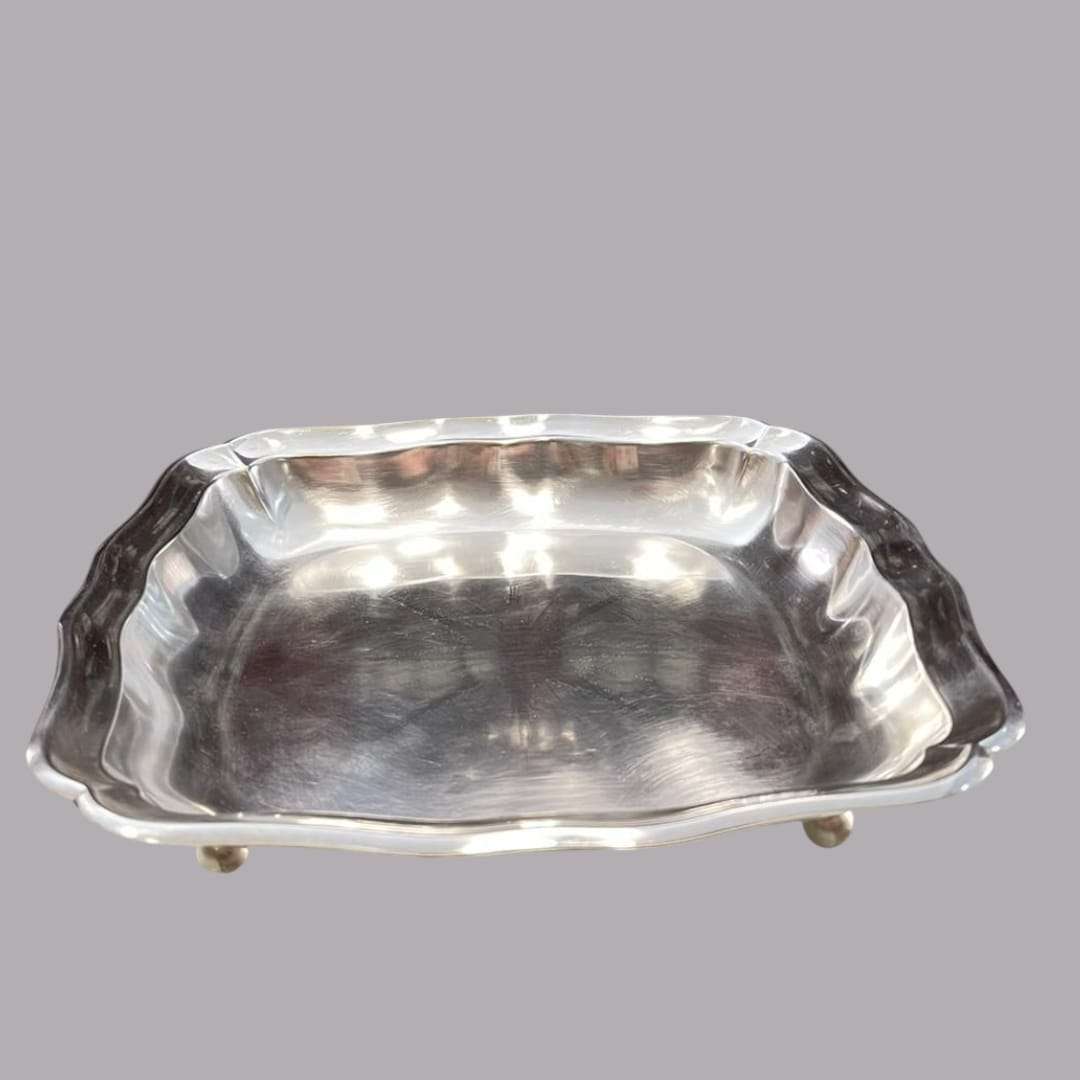 Perspectiva frontal de la bandeja con patas, mostrando su brillo y estilo atemporal.