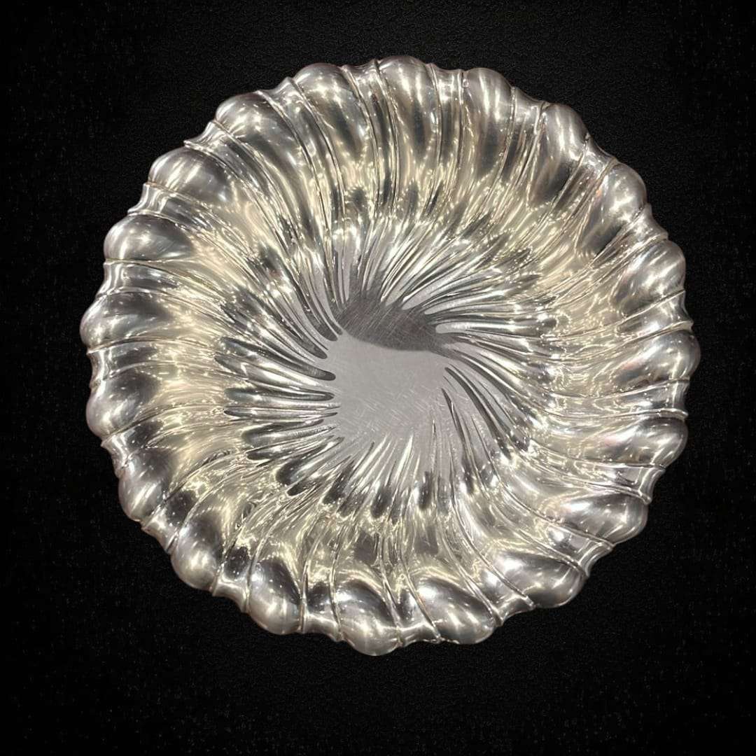 Detalle de los relieves concéntricos de la bandeja plateada.