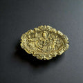
Fabricada íntegramente en bronce macizo, esta Bandeja de bronce decorativa presenta una superficie ricamente trabajada con escenas figurativas en alto relieve, donde se aprecian personajes, e