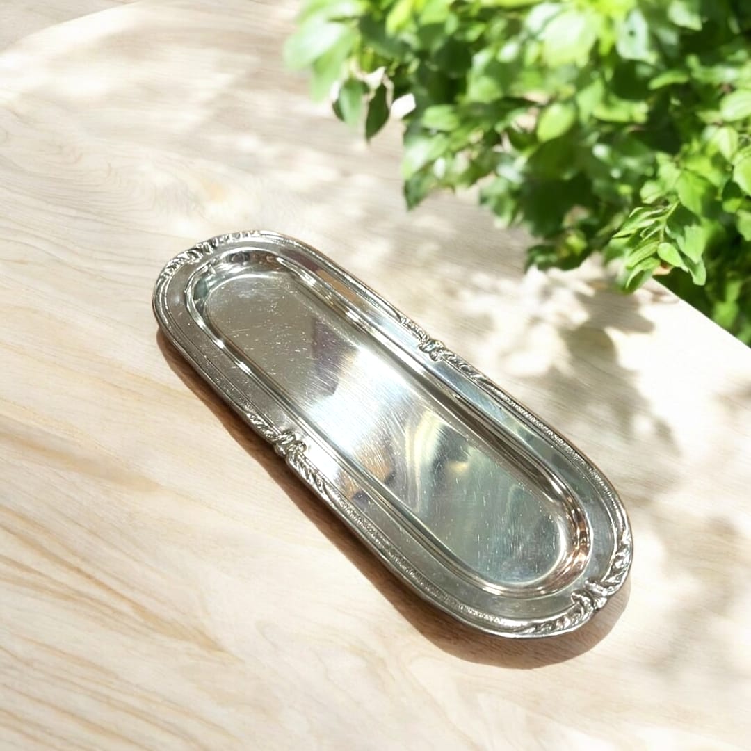 Bandeja de metal plateado alargada con diseño elegante y acabado brillante. Ideal para decoración y presentación en eventos sofisticados.