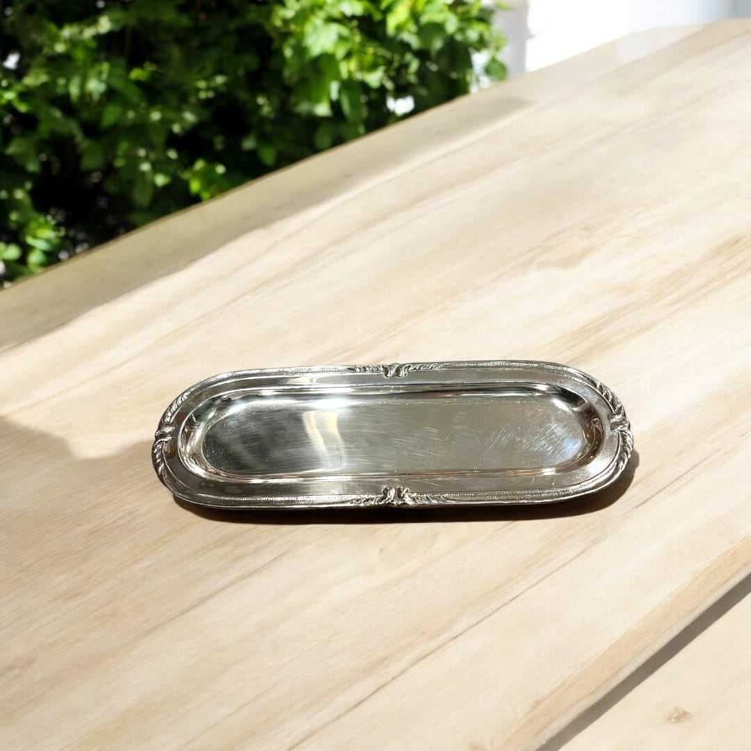 Bandeja de metal plateado alargada con diseño elegante y acabado brillante. Ideal para decoración y presentación en eventos sofisticados.