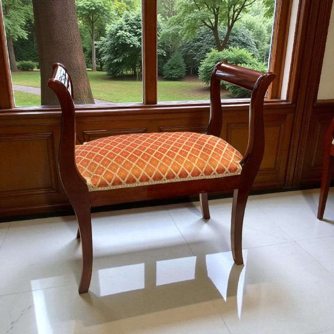 Banqueta de caoba con tapizado clásico en tonos anaranjados.