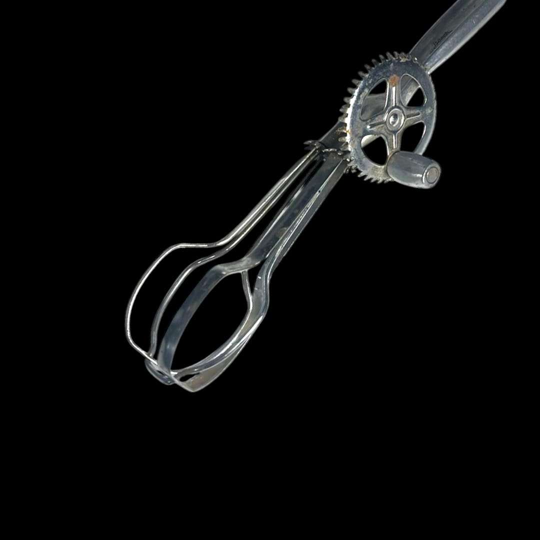 Detalle del engranaje metálico de la batidora manual antigua.