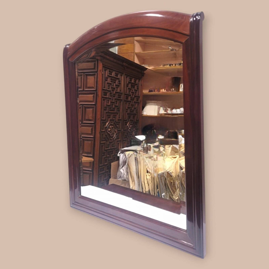 Espejo de caoba con cristal biselado y marco arqueado, ideal para decoración clásica en interiores elegantes. Calidad artesanal en cada detalle.