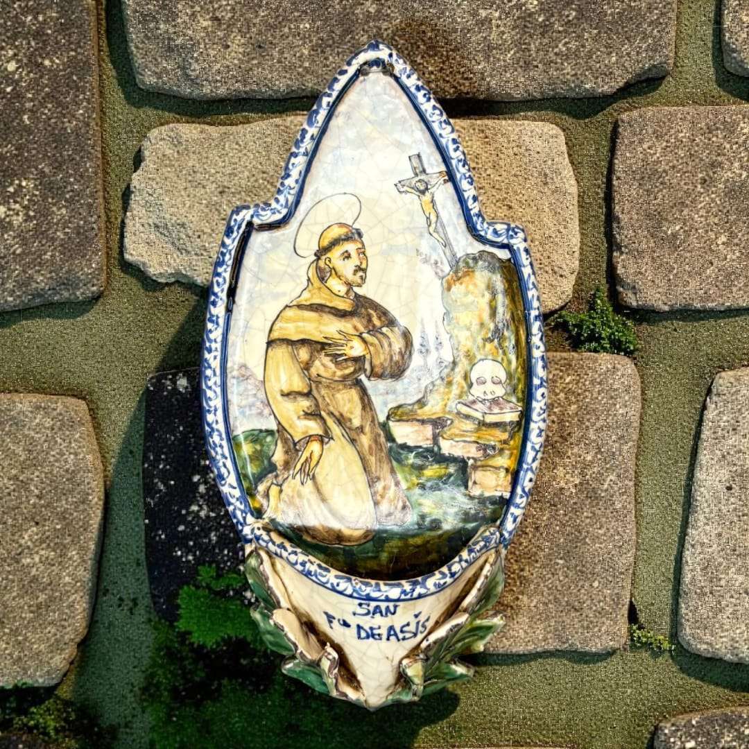 Benditera de cerámica de Talavera San Francisco de Asís antigua única con decoración religiosa pintada a mano sobre fondo de piedra. Ideal para decoración del hogar o colección devocional.
