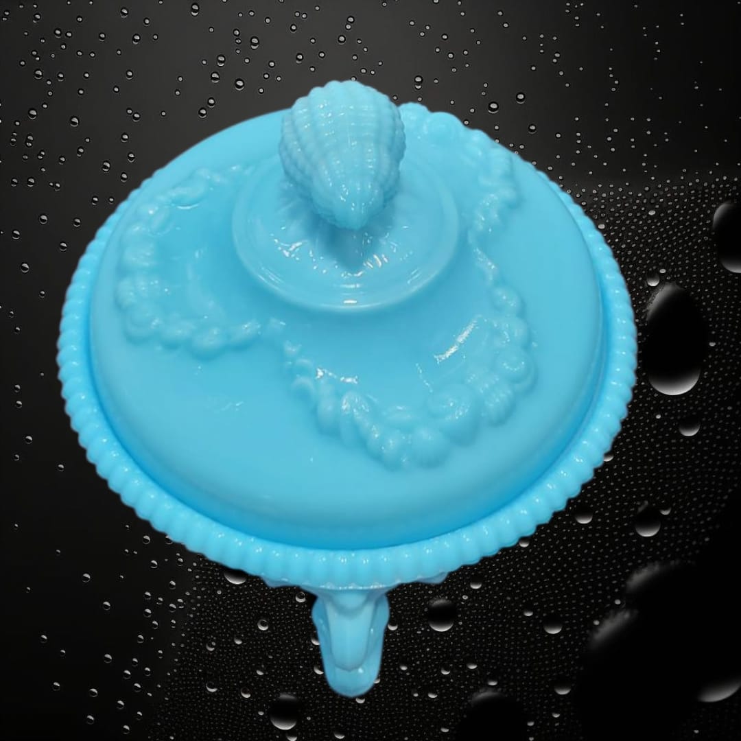 Vista superior de bombonera de opalina azul con tapa en forma de concha y detalles florales. Pieza decorativa de edición limitada.