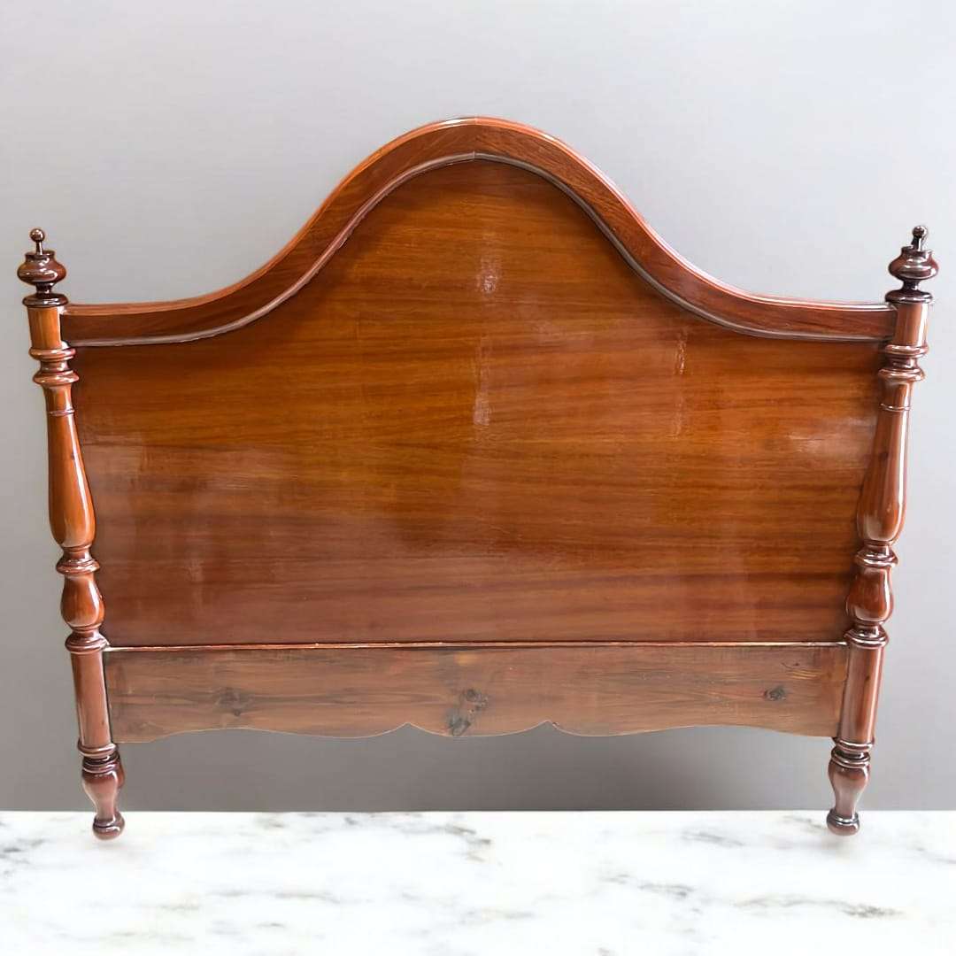 Cabecero de cama de caoba con acabado brillante y torneado, diseño clásico con forma curva y postes decorativos, ideal para dormitorios elegantes.