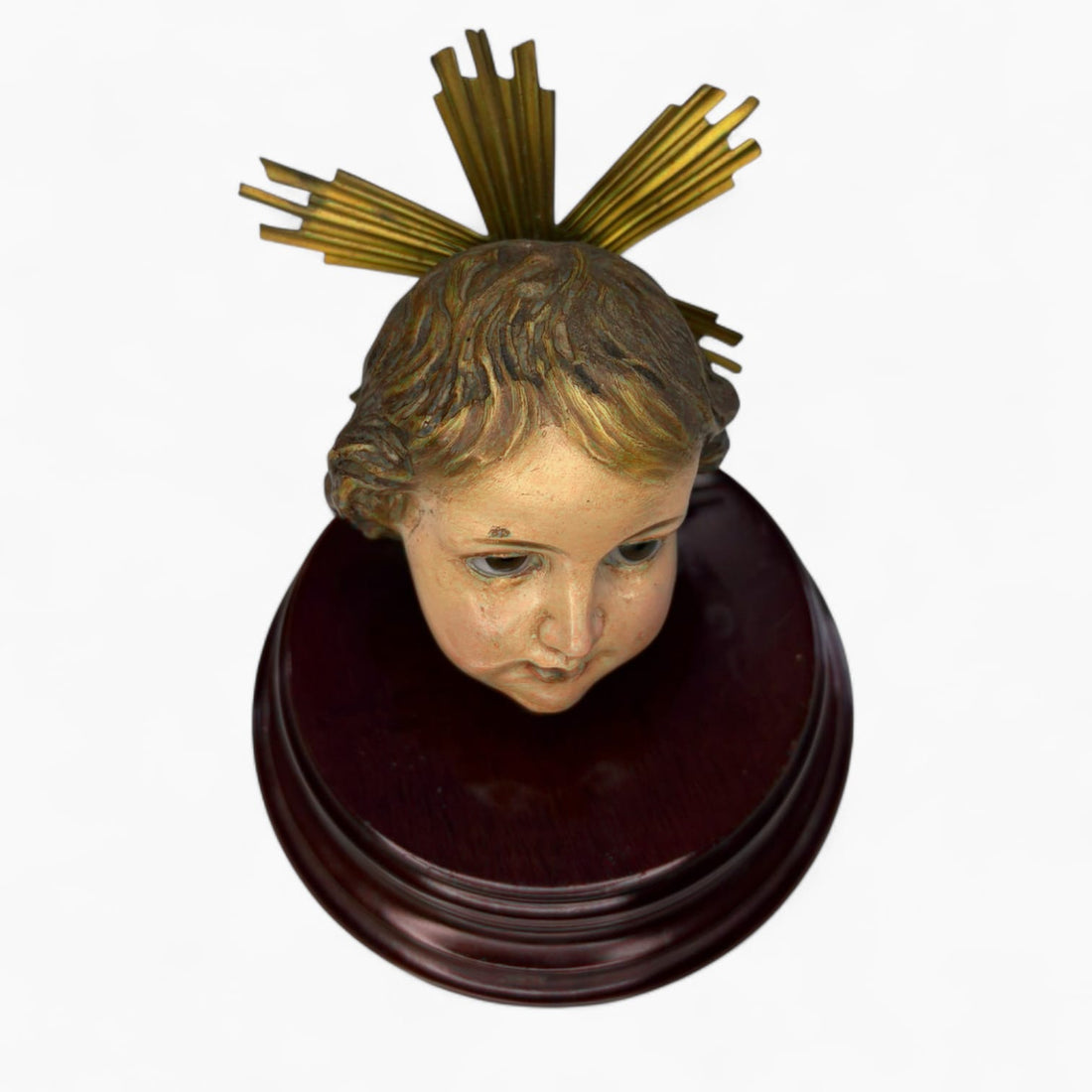 Cabeza de Niño Jesús Olot sobre peana de madera vista superior.