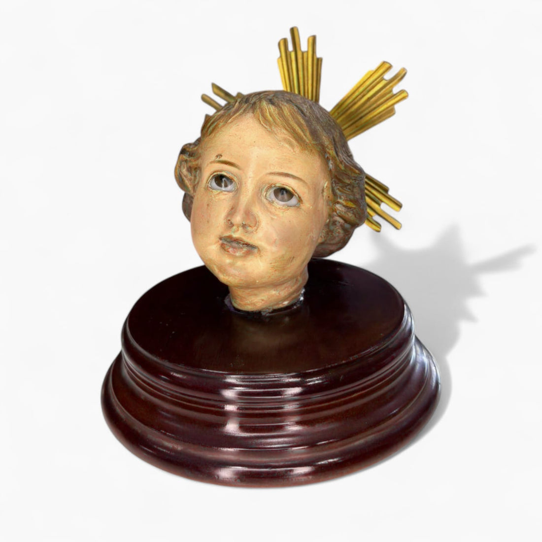 Cabeza de Niño Jesús Olot sobre peana de madera vista superior.