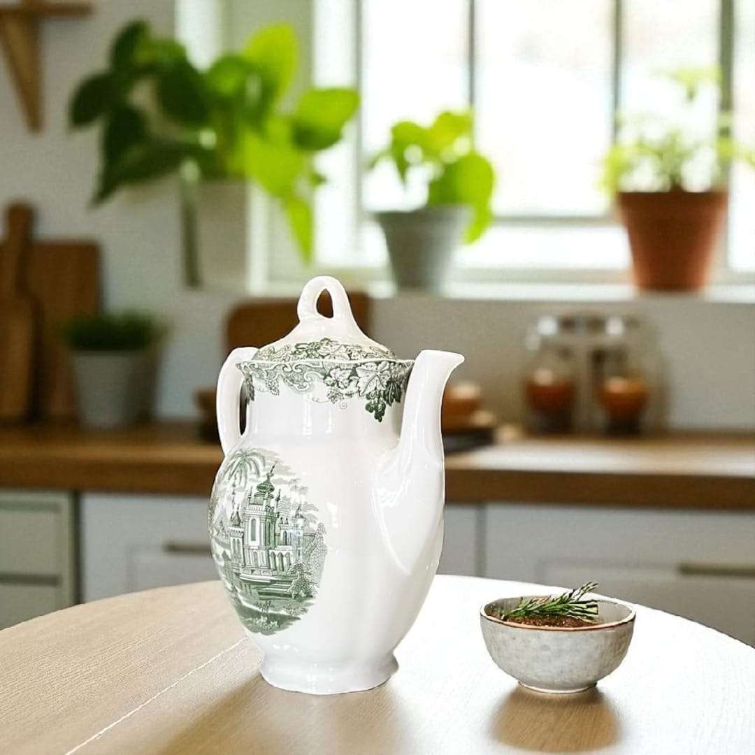 Cafetera con taza de loza a juego, reflejando la elegancia de un servicio de café tradicional.