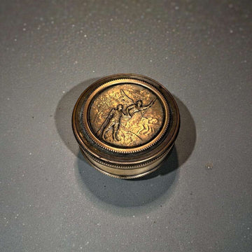 La caja redonda de metal con relieve es una pieza decorativa versátil y atemporal, ideal tanto para uso personal como para lucir en una vitrina. 