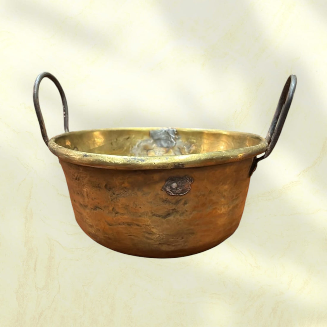 Caldero antiguo de metal con asas de hierro, pieza rústica ideal para decoración vintage en interiores o exteriores.